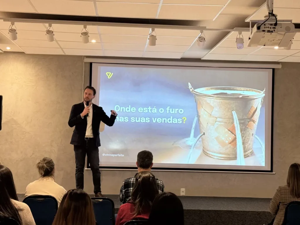 Francisco Issler apresenta o slide Onde está o furo nas suas vendas, com a imagem de um balde remendado, na palestra Tudo é Vitrine em Santa Rosa (RS)
